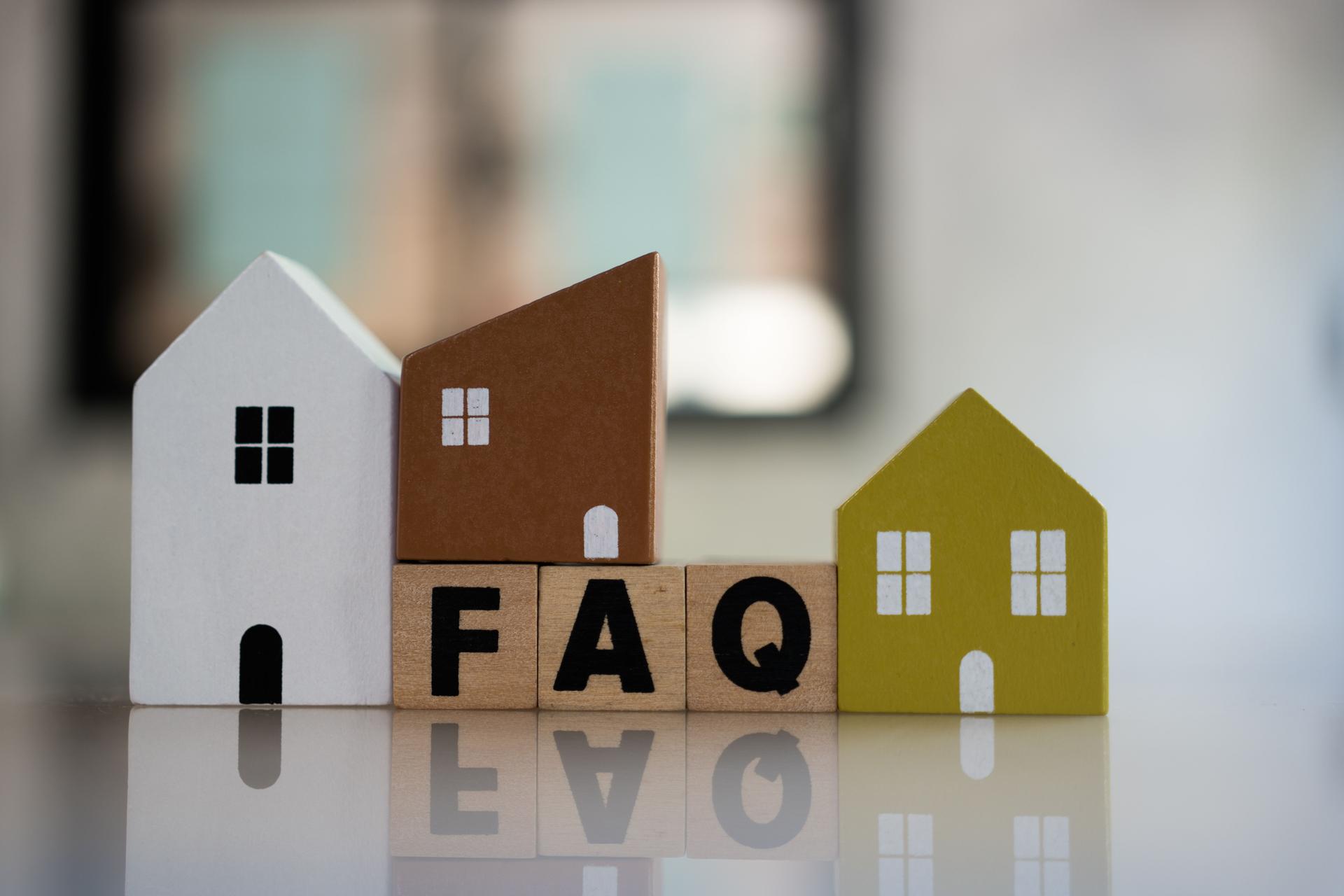 Cubes with message FAQ surrounded by wood home